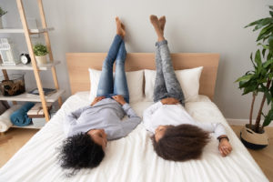 A mother and teen lay on a bed as they talk to one another. Therapy for teens can help you better communicate today. Learn more about therapy for teens in Mickelton, NJ and other services including online therapy for teens in New Jersey from the comfort of home. 08085