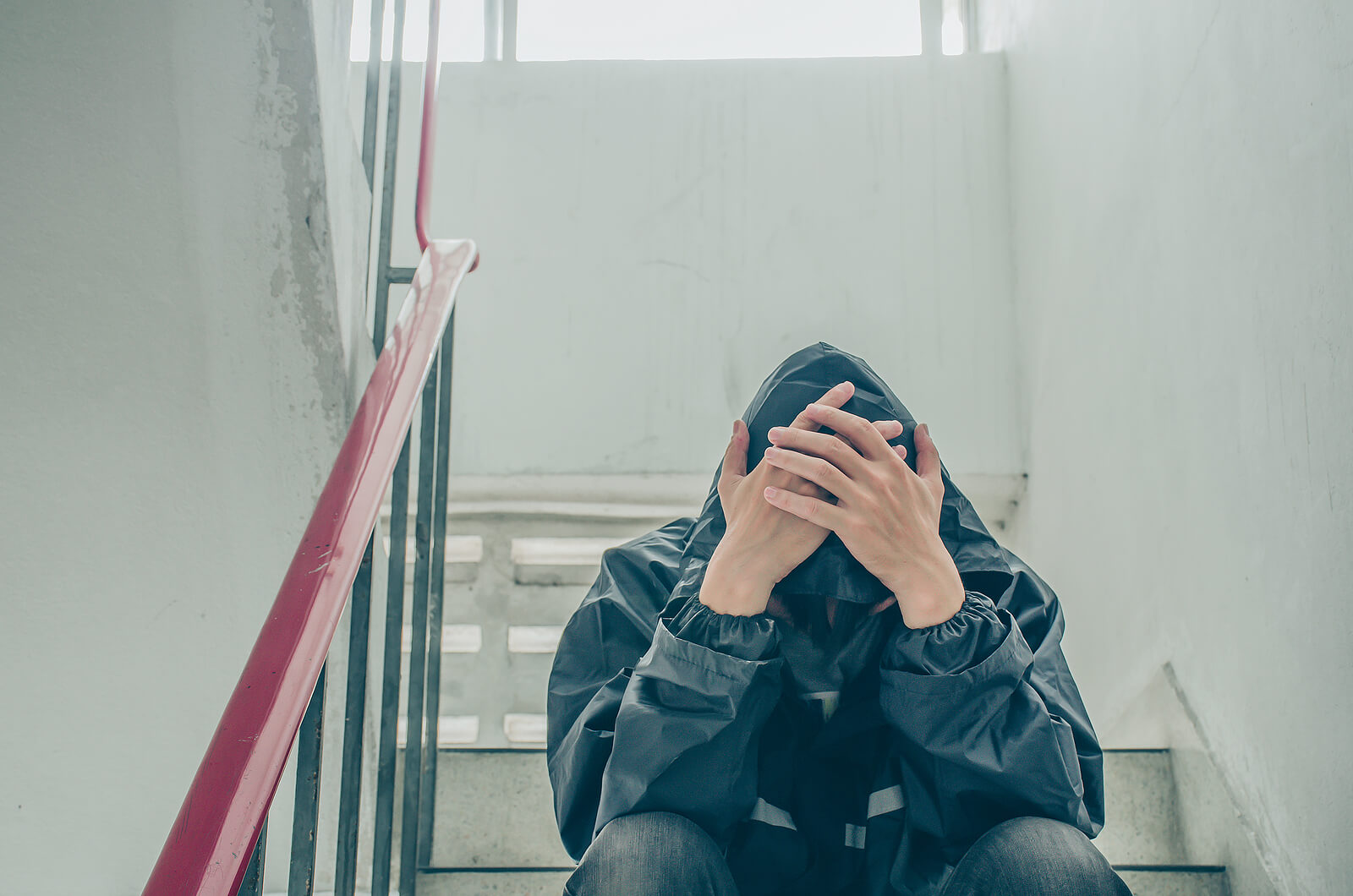 A teen sits in a stairway with their hoodie and hands covering their face. Therapy for teens in South Jersey can offer support for teens with anxiety. Contact an anxiety therapist in Swedesboro, NJ to learn more about therapy for teens in Mickleton, NJ. Our team offers therapy for anxiety in South Jersey and more! 08028 | 08056