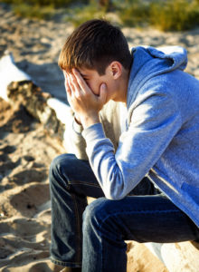 A teen boy sits as he covers his face with his hands. This could represent the anxiety that therapy for teens in South Jersey can offer. Learn more about therapy for teens in Mickleton, NJ by contacting a therapist for teens ni Swedesboro, NJ today! An anxiety therapist can offer more support! 08028 | 08056