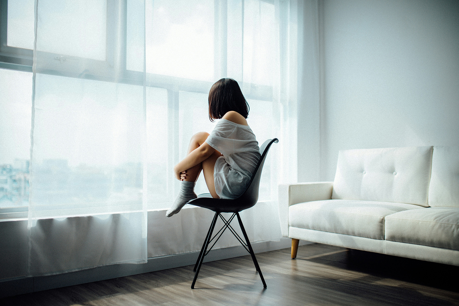 a woman in a jean jacket sitting on a bench