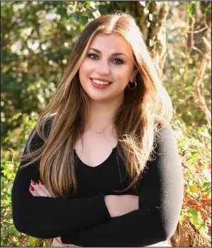 a woman with her arms crossed posing for a picture