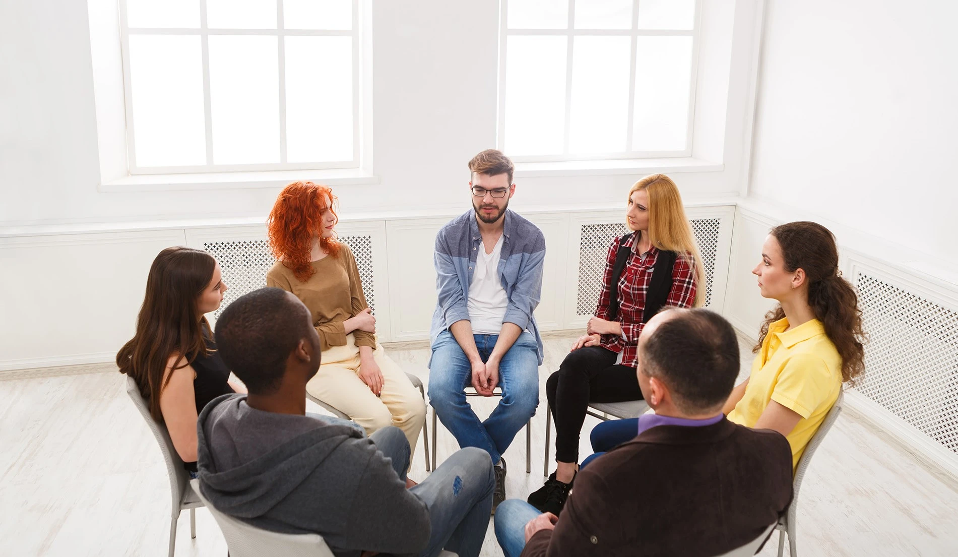 a group of people sitting in a circle talking