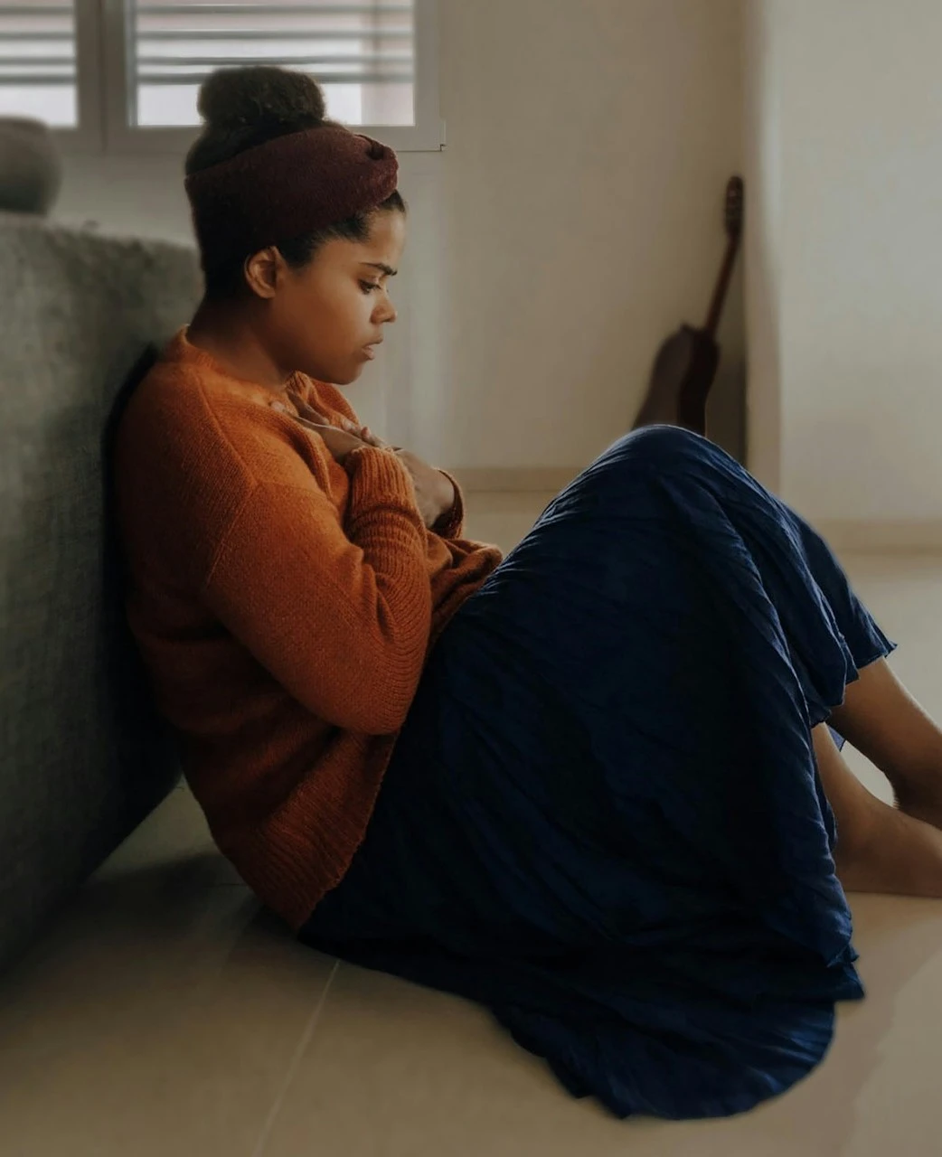 a woman sitting on the floor next to a couch