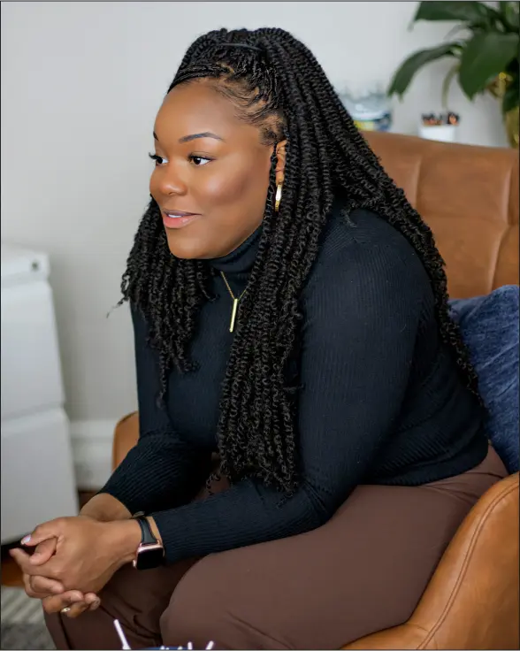 a woman sitting on top of a brown chair