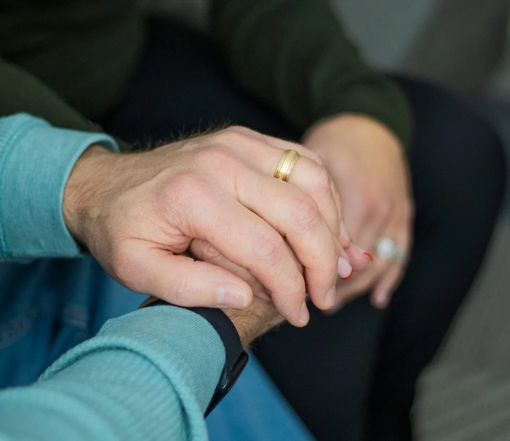 a close up of two people holding hands