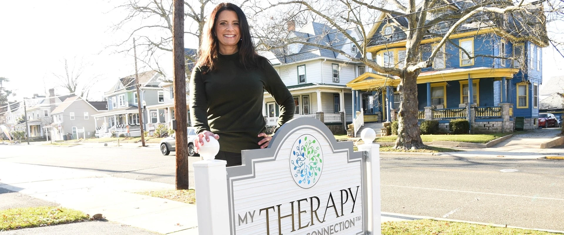 a woman standing in front of a sign that says my therapy