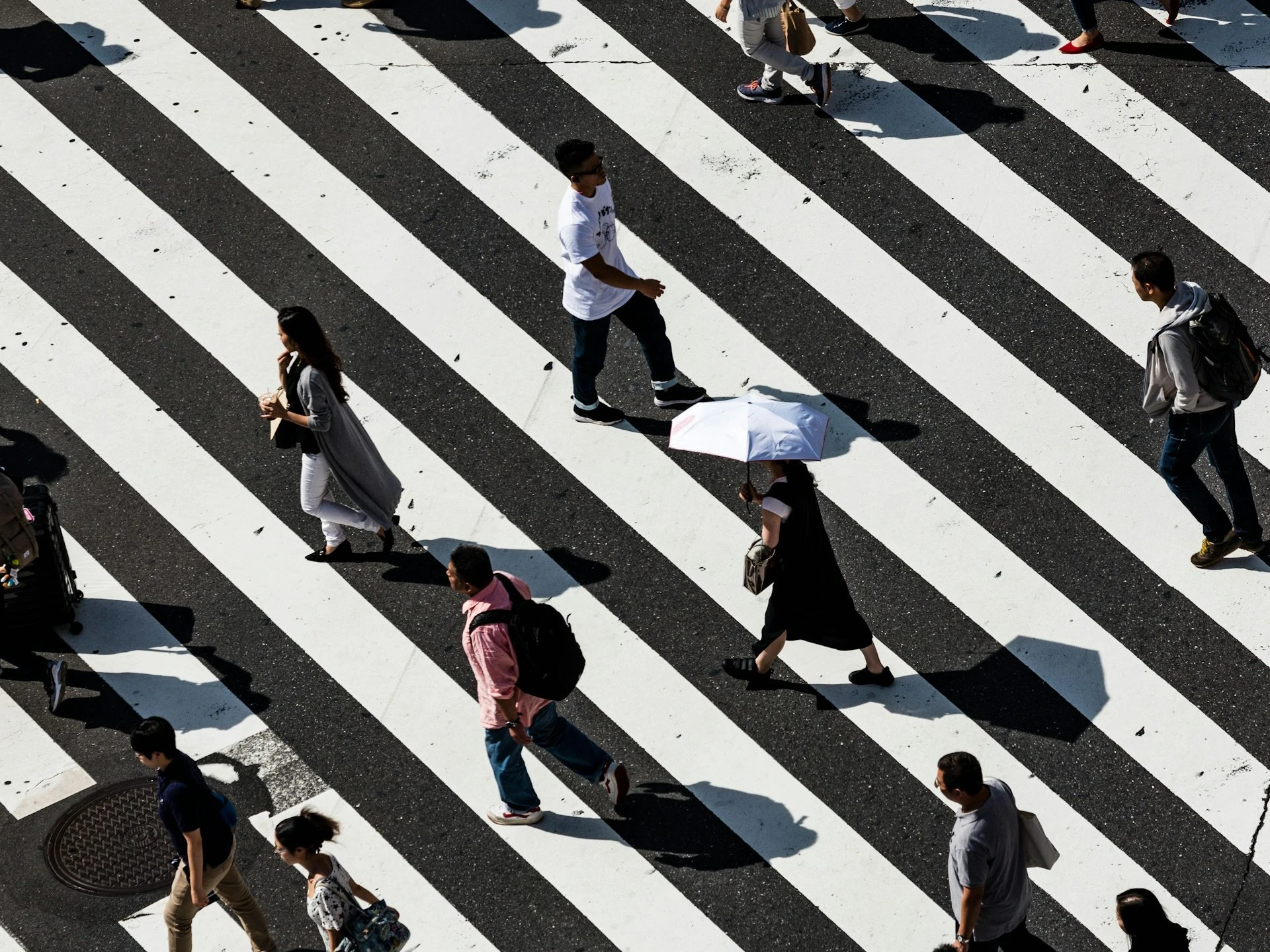 a group of people walking across a cross walk