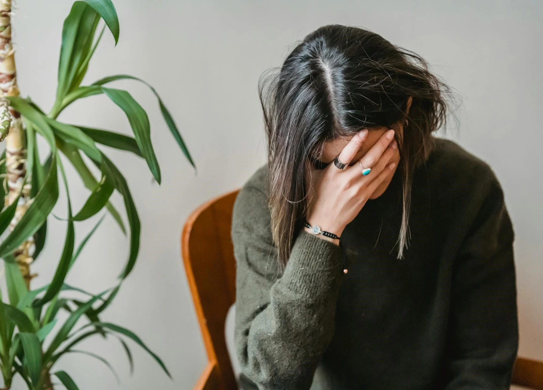 a woman sitting in a chair with her head in her hands