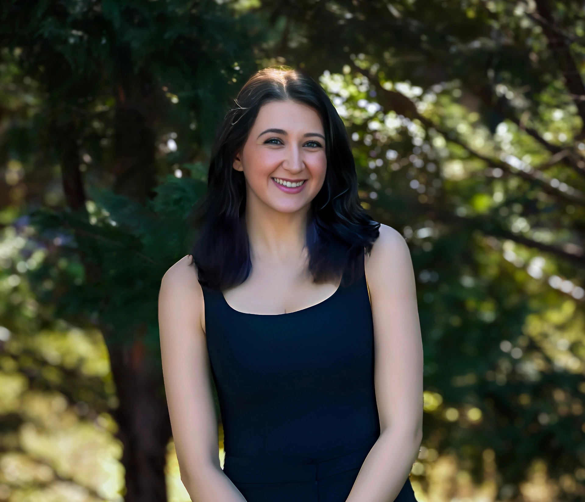 a woman named Abigail Hamilton in a black dress standing in front of trees