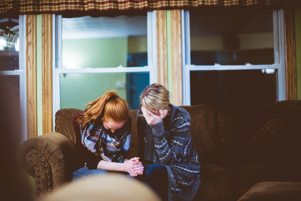 a couple of women sitting on top of a couch