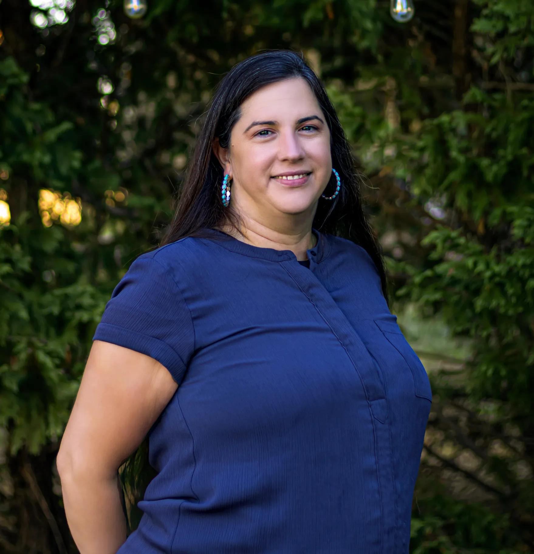 a woman in blue shirt smiling for a photo