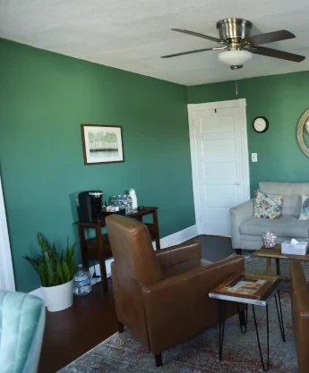 a living room filled with furniture and a ceiling fan