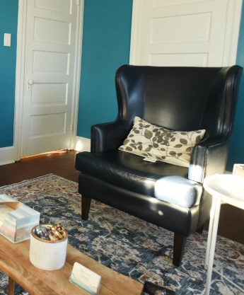 a living room with blue walls and a black chair