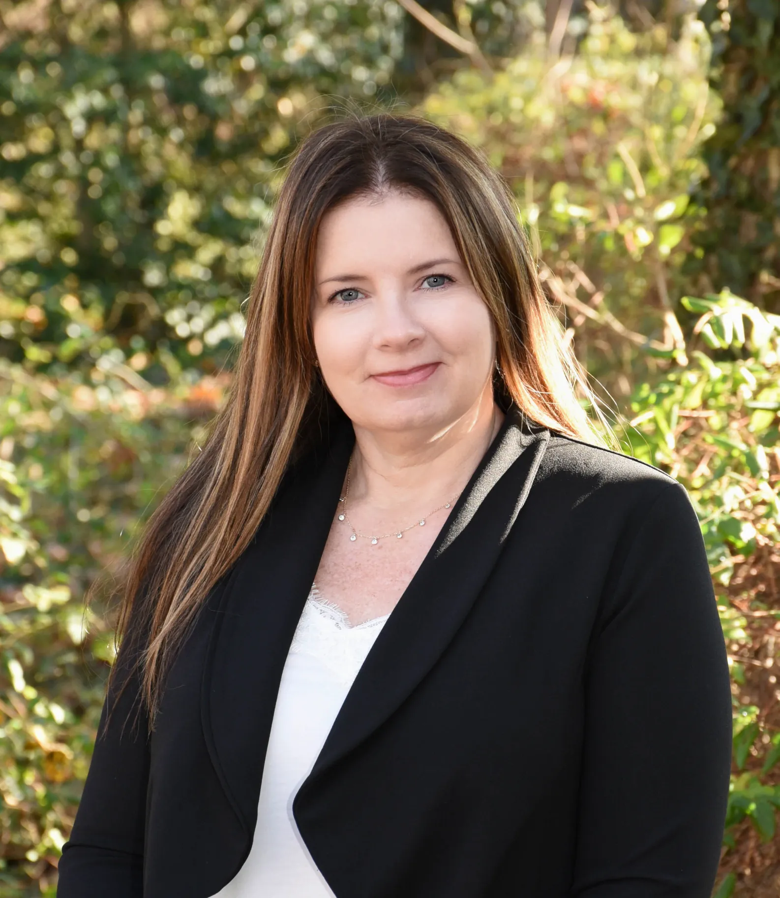 a woman named Kim Kimpers standing in front of some trees