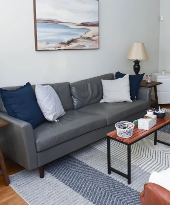 a living room filled with furniture and a painting on the wall