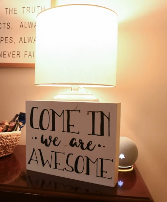 a wooden sign that says come in we are awesome