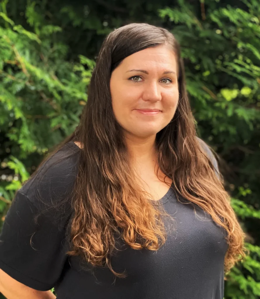 a woman named Amber Seibert standing in front of some trees