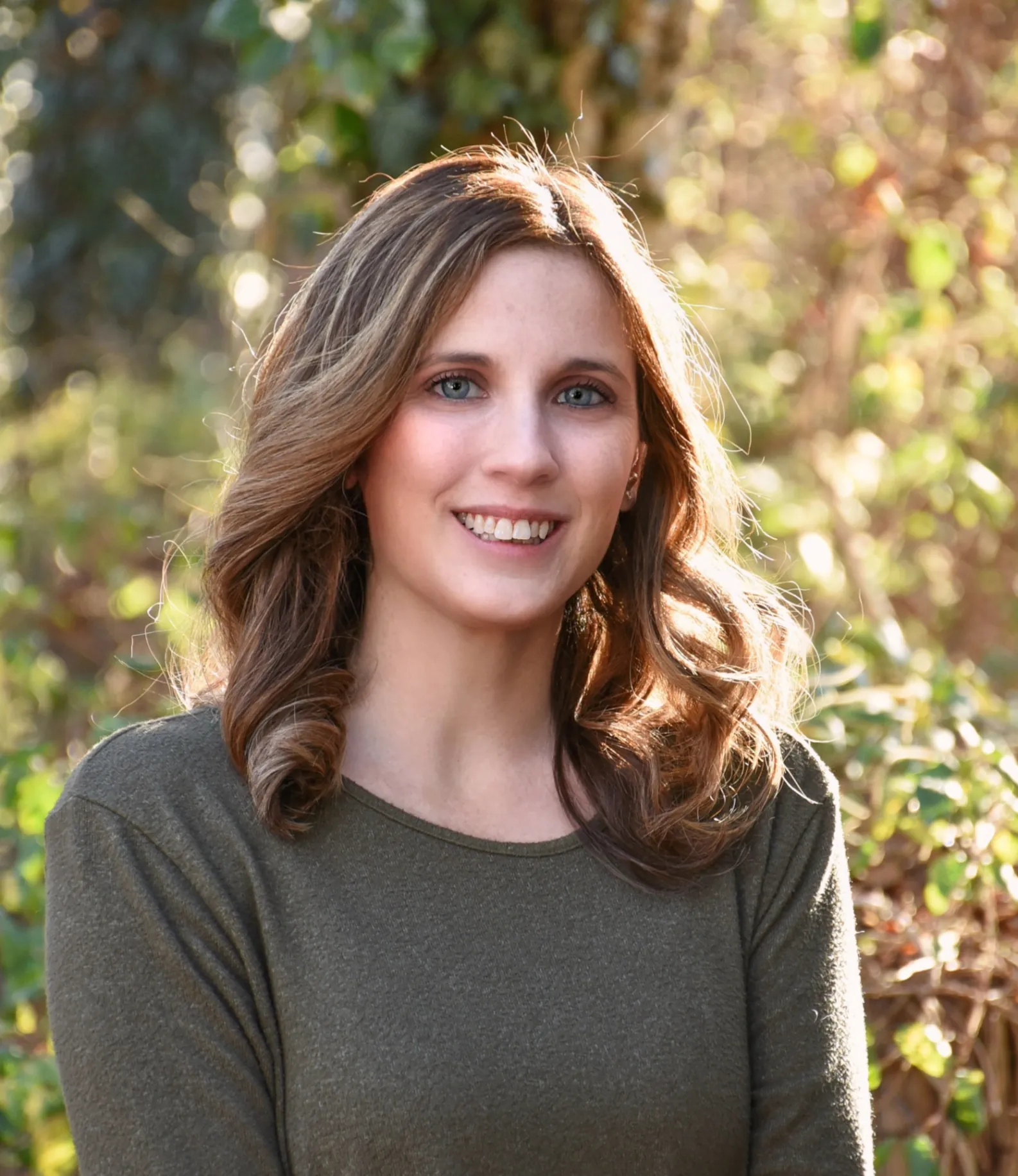 a woman named Caitlin Alford in a green shirt is smiling for the camera