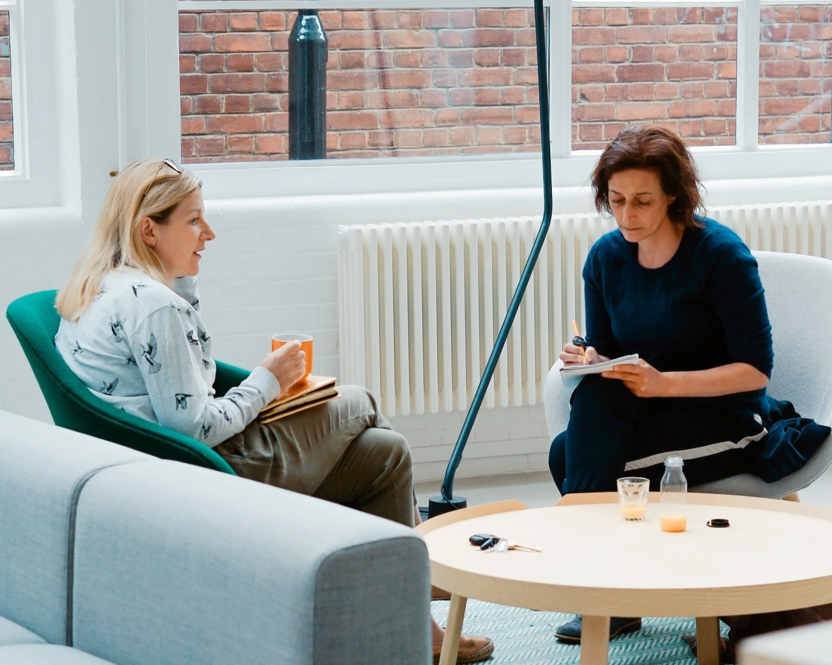 two women sitting in chairs in a living room