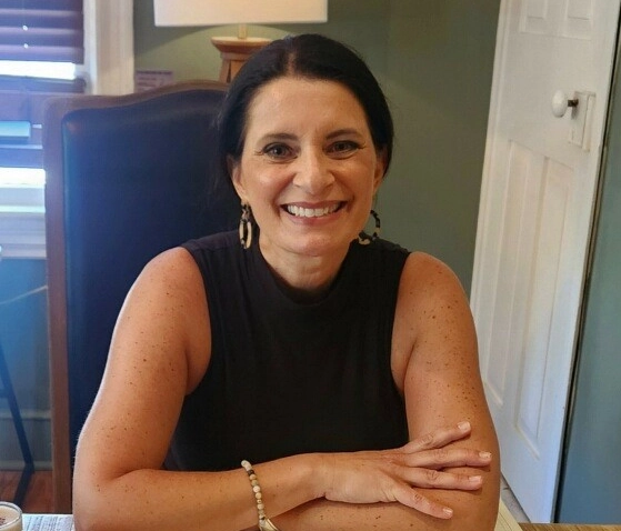 a photo of a woman in a black tanktop smiling