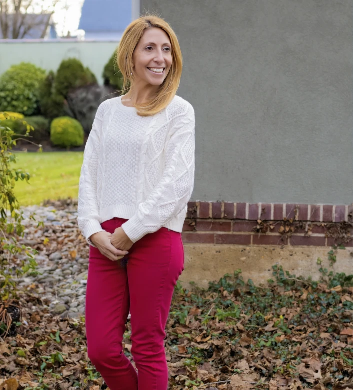 a woman named Heidi Wimberg in a white sweater and pink pants