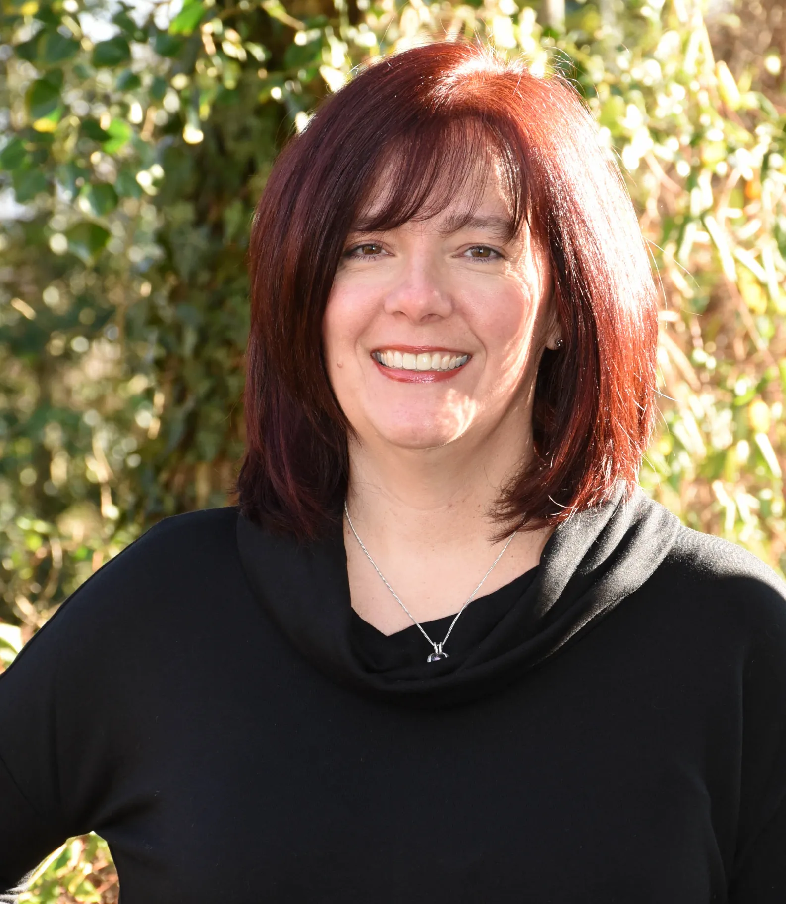 a woman named Kristine Fredericksdorf with red hair and a black hoodie