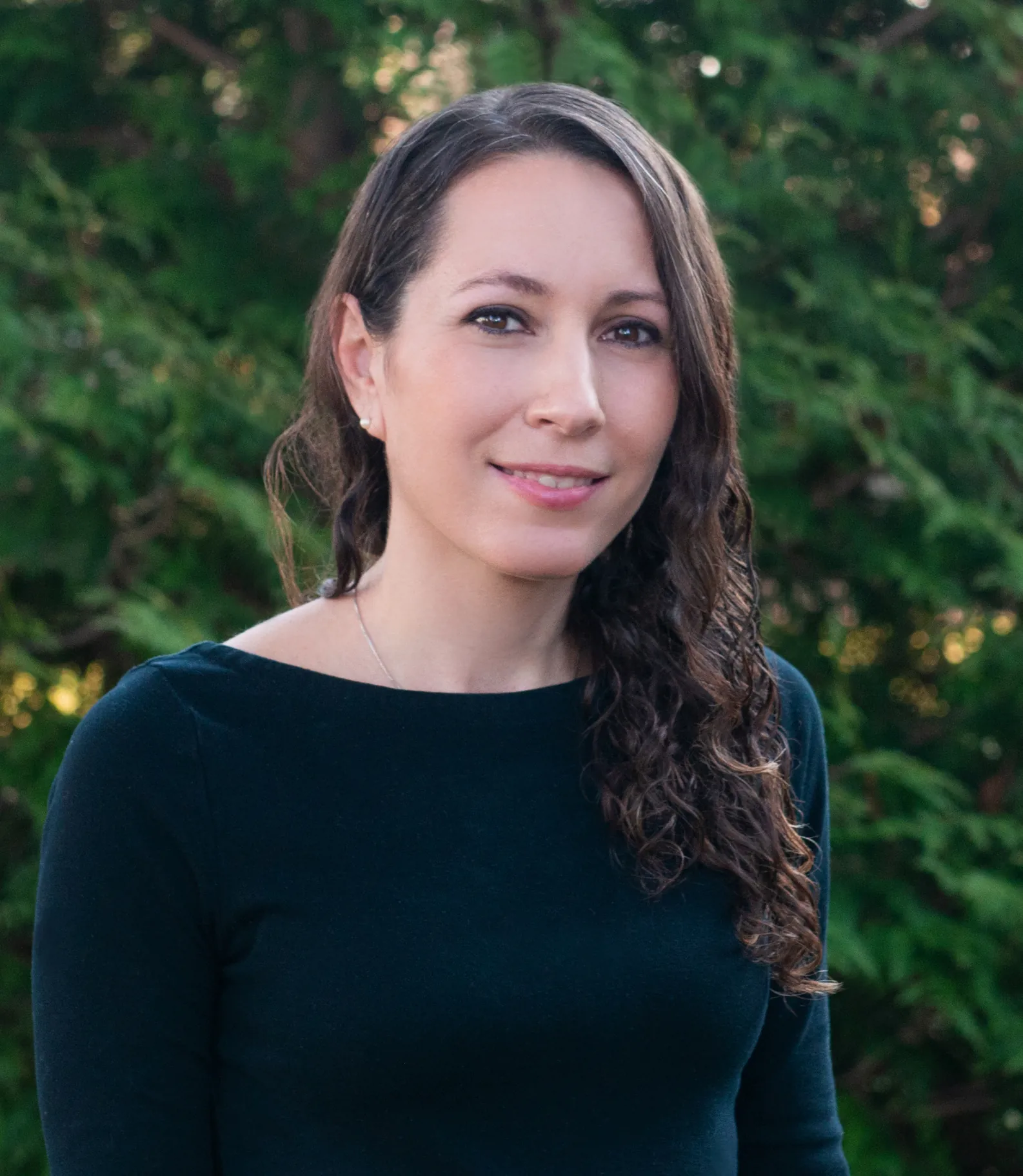 a woman named Rachel Verdi standing in front of some trees